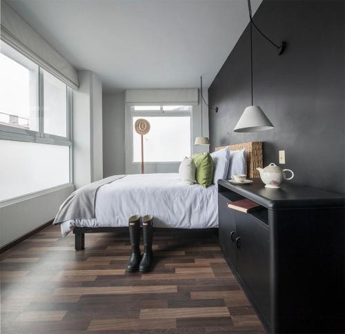 a bedroom with a bed with a black dresser and a window at Lusitania Suites in Orizaba