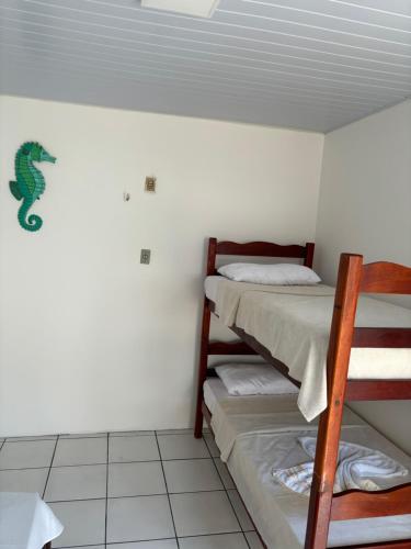 a room with two bunk beds and a lizard on the wall at Chale Blok in Salinópolis