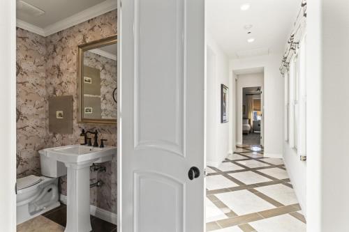 a white bathroom with a sink and a mirror at Luxury Griffin Estate 4900sf Compound Pure luxury WALK TO COACHELLA AND STAGECOACH in La Quinta