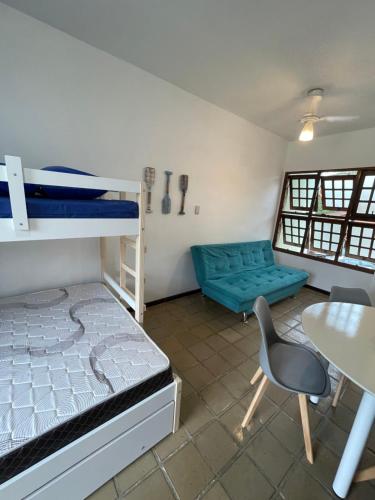 a room with a bunk bed and a table and a chair at Pé na Areia na Praia das Toninhas - Villagio 24 Porto Feliz in Ubatuba