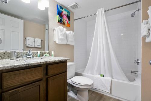 a white bathroom with a toilet and a shower at Silver Lake Resort in Orlando
