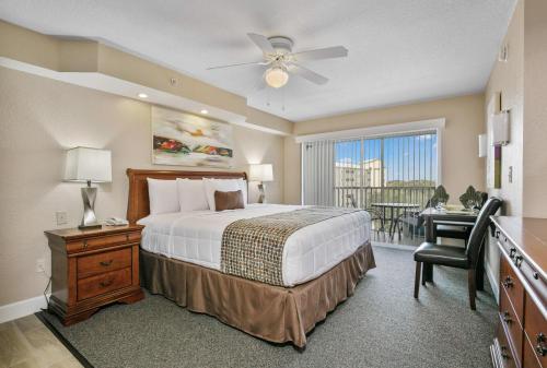 a bedroom with a bed and a desk and a window at Silver Lake Resort in Orlando