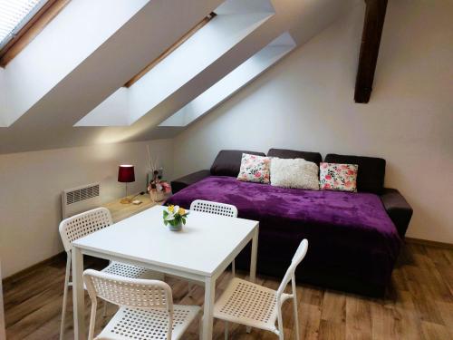 a living room with a purple bed and a table at Byt Komenskeho #2# v historickém centru Hradec Králově in Hradec Králové