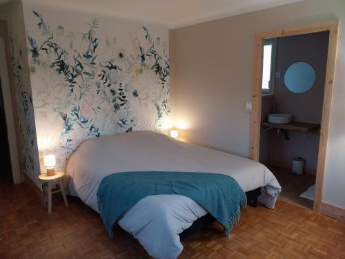 une chambre avec un lit avec un papier peint bleu et blanc dans l'établissement Gîte Sous le marronnier jusqu'à 10 personnes, à Hadol