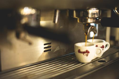 a cup of coffee being brewed in a espresso machine at Hotel-Restaurant 1735 in Speyer