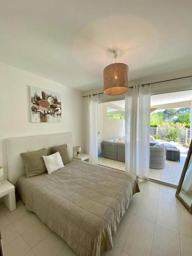 une chambre avec un lit et une grande fenêtre dans l'établissement Rez-de-jardin 6 - Accès direct à la plage, à Calvi