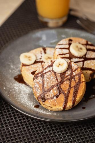 three donuts with chocolate and banana slices on a plate at Casa Tavera- Adults Only in Mérida