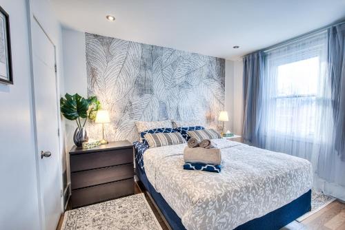 a bedroom with a bed with a blue and white bedspread at Plateau Escape & Nightlife Adventures! Downtown Super Value! Full 1BR Apartments in Montréal