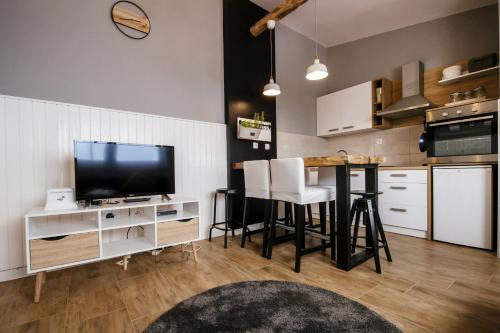 a kitchen with a television and a table with chairs at MY DALMATIA - Beach Apartment Neno in Ražanac