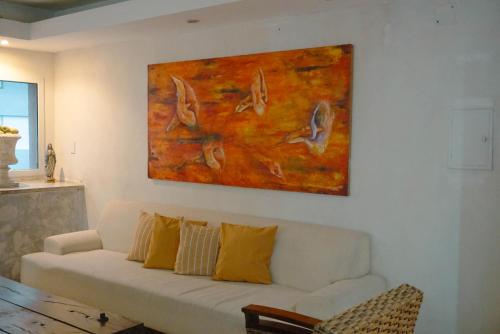 a living room with a white couch and a painting at House Park Boutique - Casa de Huéspedes in Santa Fe