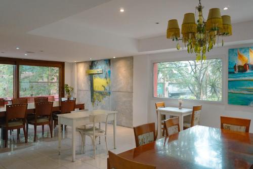 a dining room with tables and chairs and a large window at House Park Boutique - Casa de Huéspedes in Santa Fe