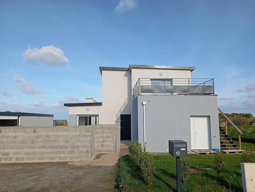 a white house with a fence in front of it at Gîte à 400m de la mer in Ploudalmézeau