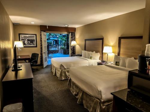 a hotel room with two beds and a balcony at Heritage Inn in Great Falls