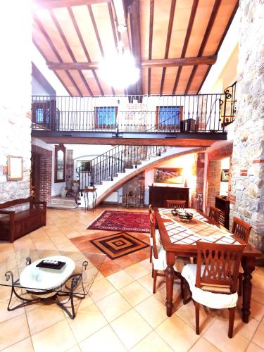 a large living room with a table and a staircase at Le Stanze del Casale Morolo in Morolo
