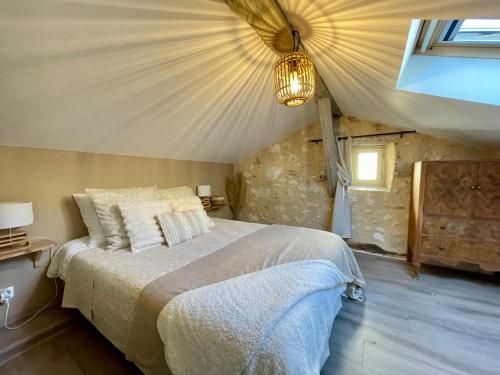 a bedroom with a large bed in a attic at Les Régniers - 2 gîtes pour partir ensemble in Eynesse