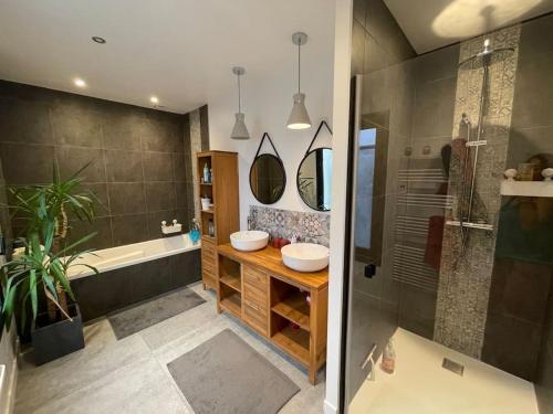 une salle de bain avec deux lavabos, une baignoire et une douche dans l'établissement Maison d'Architecte - 15 min Toulouse - Piscine, à Belberaud