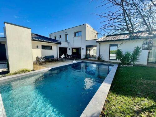 une piscine devant une maison dans l'établissement Maison d'Architecte - 15 min Toulouse - Piscine, à Belberaud