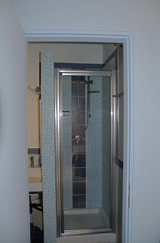 a bathroom with a shower with a glass door at AlbaChiara Suite Rooms - City Center in Trapani