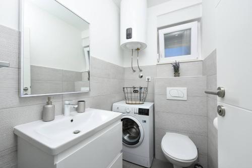 a bathroom with a sink and a washing machine at MY DALMATIA - Sea view villa Possedaria with amazing roof terrace in Posedarje