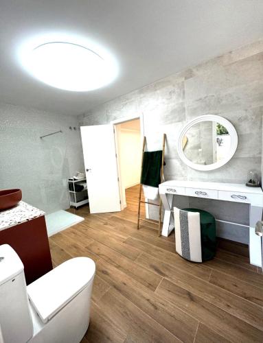 a bathroom with a toilet and a sink and a mirror at Casa rural in Cabra