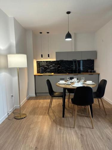 a dining room with a table and chairs and a kitchen at Apartament Kryształ in Piechowice