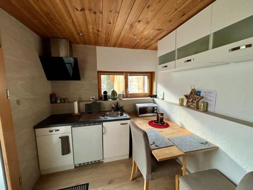 a small kitchen with a table and a sink at Mitten in den Glarner Alpen Hot Tub & Alpenblick in Ennenda