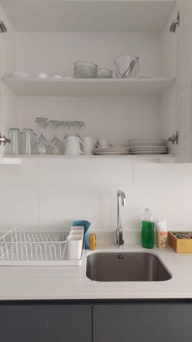 a kitchen sink with a dish rack next to it at Sunrise in La Serena