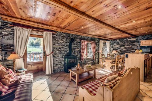 a living room with a stone wall at Chalet Les Champs Du Pont - LA GRANDE FERME 9 Pièces 15 pers. Appartement en chalet - 205m² MAE-6964 in Tignes