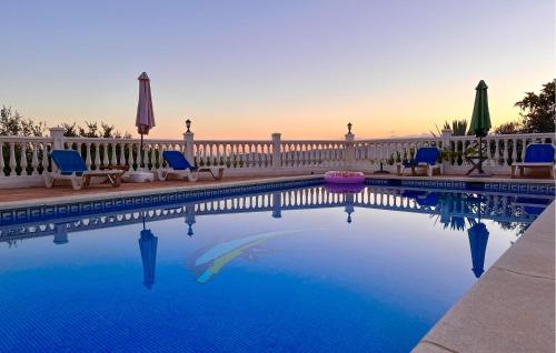 einen Pool mit blauen Stühlen und einem Zaun in der Unterkunft 5 Bedroom Cozy Home In Arenas in Arenas