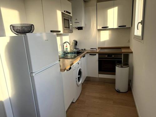 une cuisine avec un réfrigérateur blanc et un évier dans l'établissement ღ Bel Air - T4 Spacieux, Lumineux et Parking, à La Rochelle