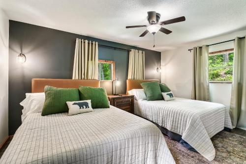 a bedroom with two beds and a ceiling fan at Cozy Mountain Cabin, Sleeps 8, Mini Golf, Hot Tub, Coffee Bar! in Sevierville