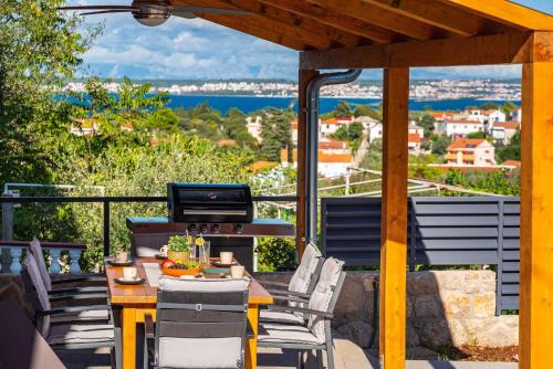 a patio with a table and chairs and a grill at MY DALMATIA - Sea view villa Nana with private swimming pool in Lukoran