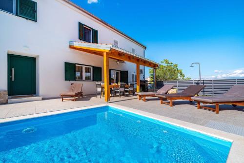a swimming pool in front of a building with a house at MY DALMATIA - Sea view villa Nana with private swimming pool in Lukoran