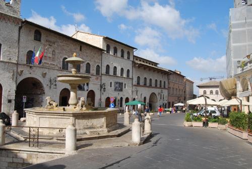 a fountain in the middle of a city street at Hotel La Rocca in Assisi