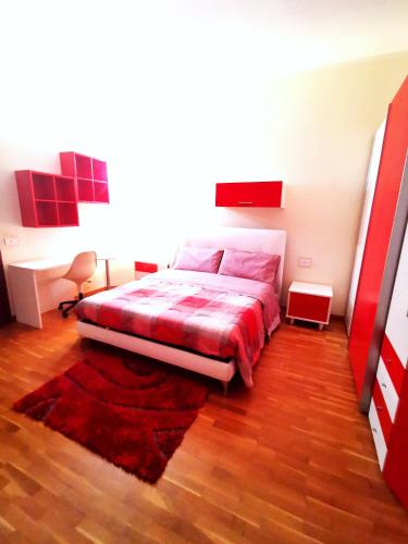 a bedroom with a bed with a red comforter at Le Stanze del Casale Morolo in Morolo