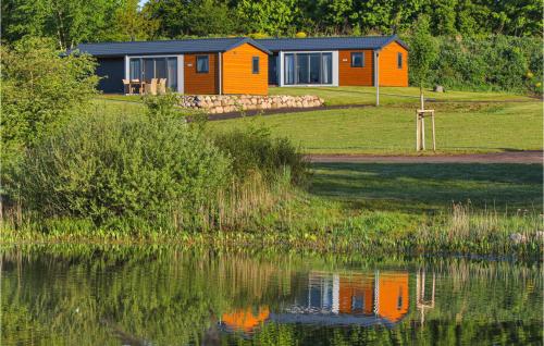 SüselにあるChalet 19 Am Seeの水の隣にあるオレンジの家