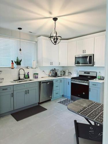 a large kitchen with white cabinets and blue appliances at Cozy & Near Downtown & Hyde Park in Chicago