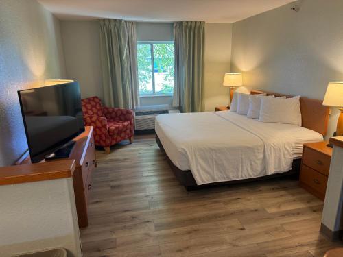 a hotel room with a bed and a flat screen tv at Wingate by Wyndham Sioux City in Sioux City