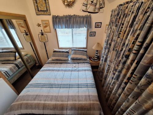 two beds in a room with curtains and a mirror at Luxurious Oceanfront Cabin 7 Getaway W Hot Tub in Smith River