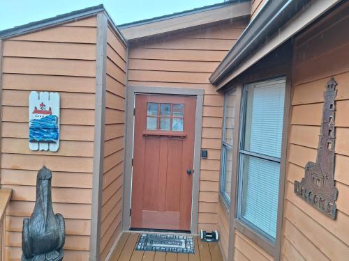 a wooden house with a red door and a window at Luxurious Oceanfront Cabin 7 Getaway W Hot Tub in Smith River