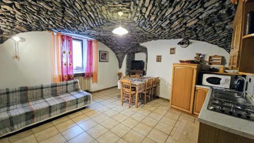 - une cuisine avec un canapé et une table dans une chambre dans l'établissement Lo Tatà - Maisons de Charme - Caratteristico Appartamento a 2 passi da Courmayeur, à Pré-Saint-Didier