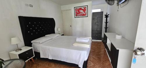 a small bedroom with a bed with white sheets at Pacharodeo & Hospedaje in Pachacamac