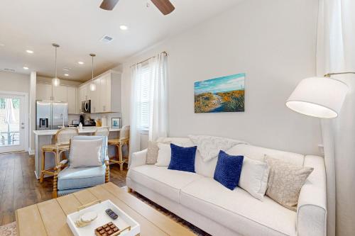 un soggiorno con divano bianco e cuscini blu di Mini Manor off Meeting a Charleston