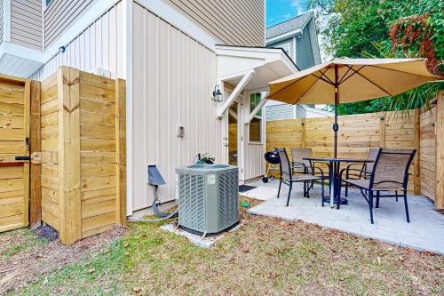 un patio con un tavolo e un ombrellone di Mini Manor off Meeting a Charleston