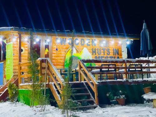 a log cabin in the snow at night at Wooden Huts In Mestia in Mestia