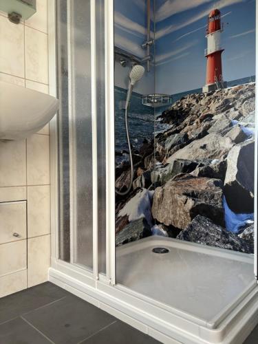a bathroom with a bath tub next to a lighthouse at Urlaub beim Käptn! Freistehendes Premium Nordsee-Ferienhaus mit Fahrrädern, Stellplatz und Garten, 150m zur Nordsee in Butjadingen