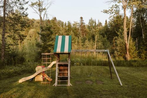 a play set in a yard with a swing at Wolegib Waterfront Retreat in Muskoka in Huntsville