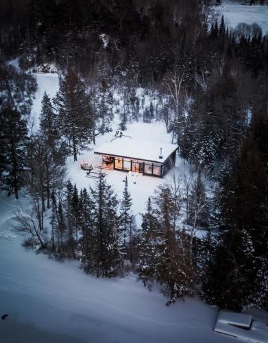 a house in the middle of a snow covered forest at Wolegib Waterfront Retreat in Muskoka in Huntsville