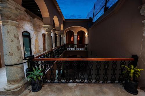 an old building with a balcony with two plants at Casa 1800 Oaxaca Boutique Hotel City Center based in Oaxaca City