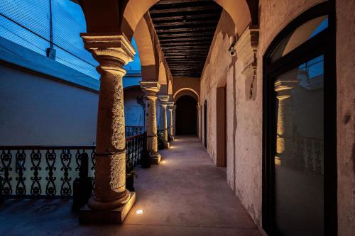 an alley with columns in a building with lights at Casa 1800 Oaxaca Boutique Hotel City Center based in Oaxaca City